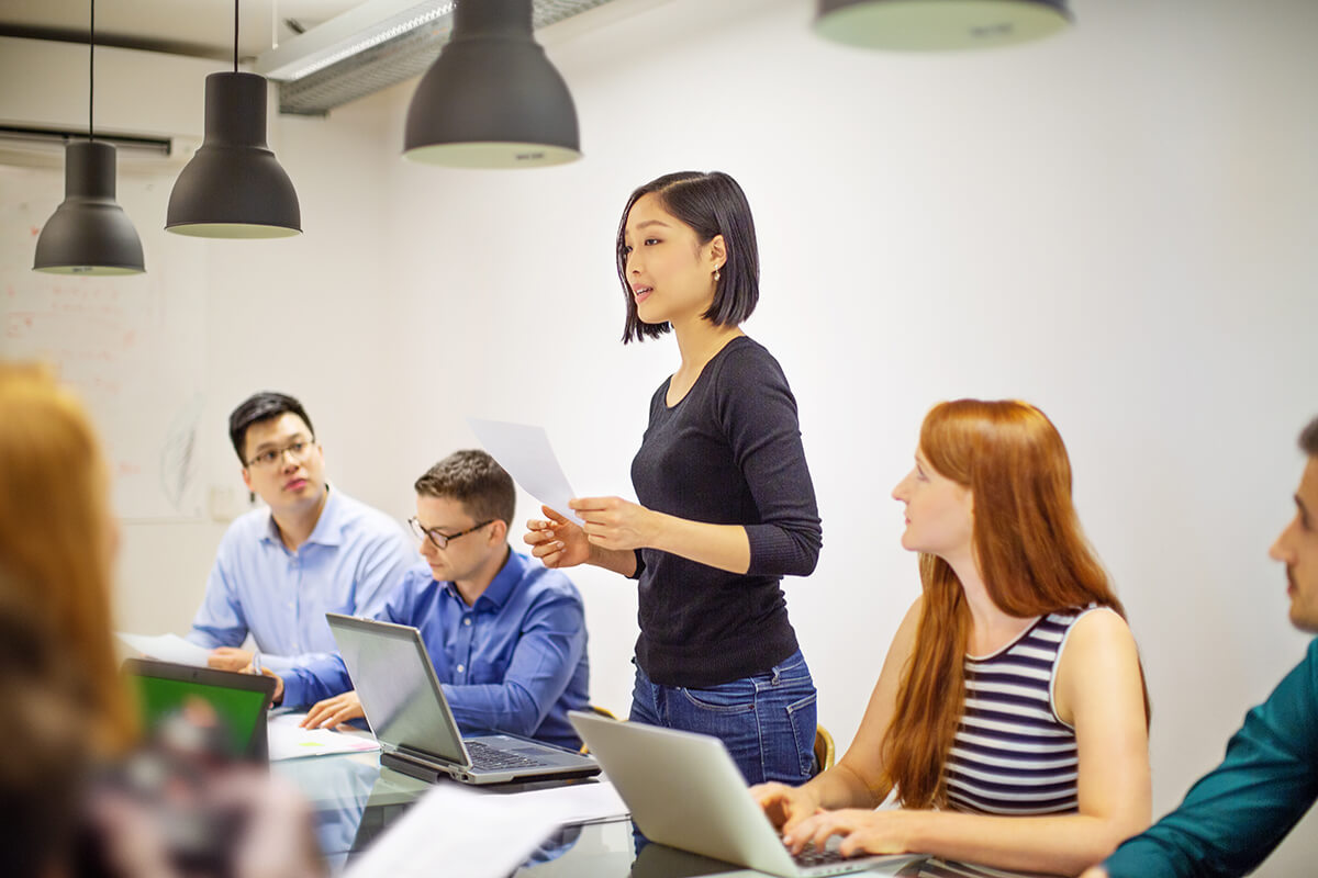 Photo of a woman speaking at a work meeting for Learning Forward Website
