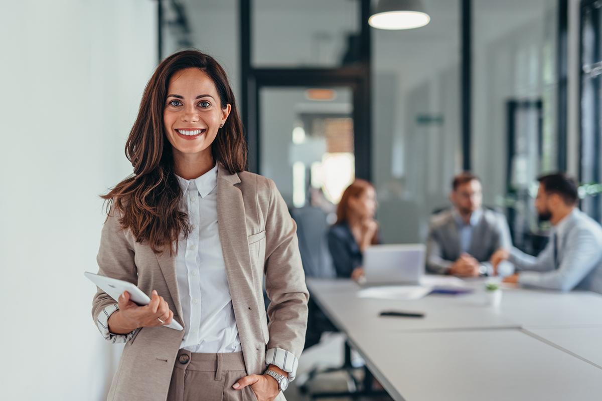 Business woman holding a tablet in a modern office setting.