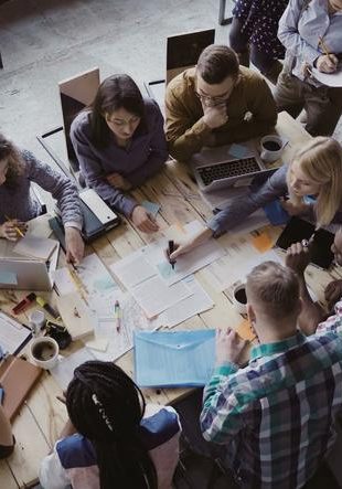 top view of mixed race business team sitting at the table